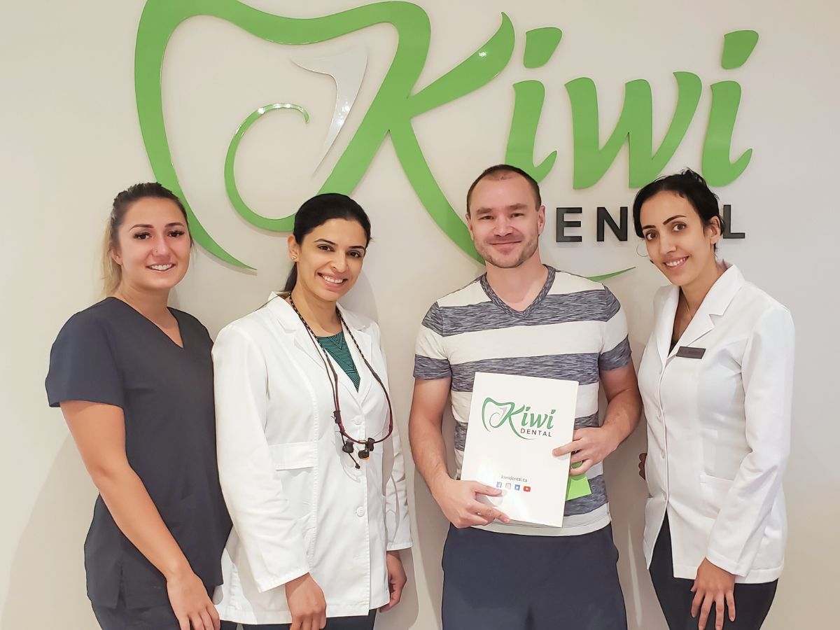 Kiwi Dental team members with a patient after a visit